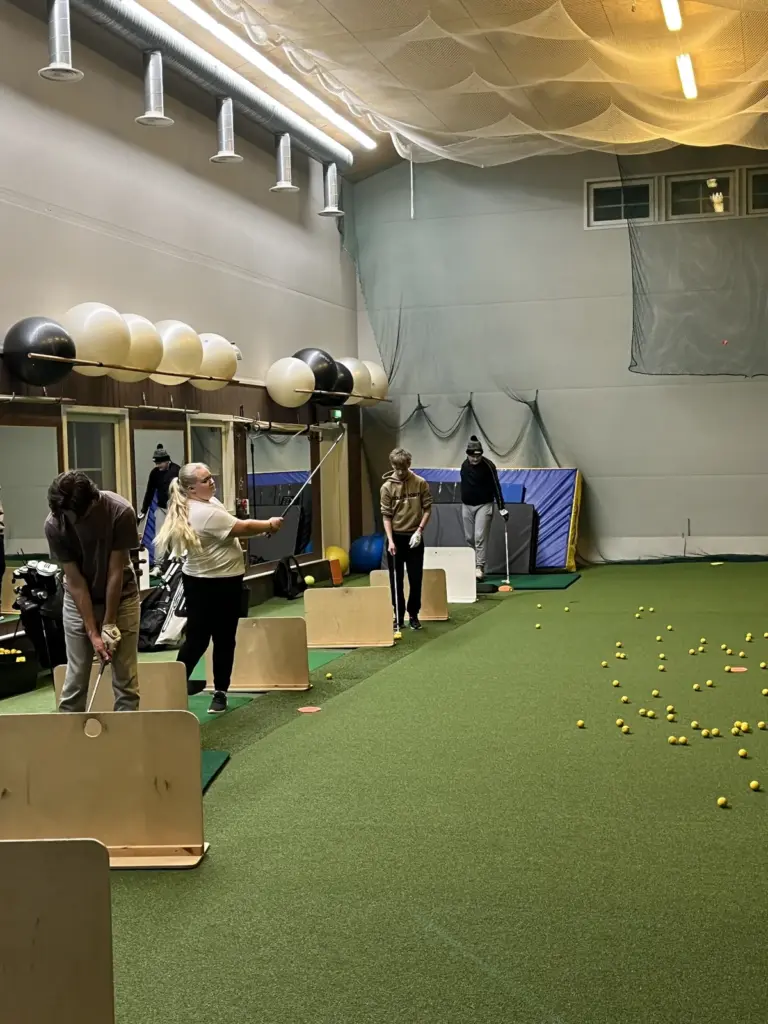 Harjoittelua golfhallissa, kuntopallot seinällä